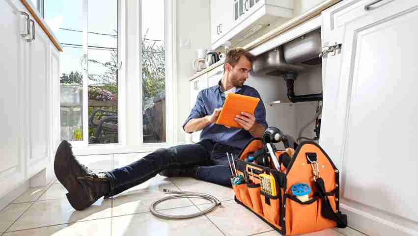 Dallas home remodeling company plumber inspects damaged pipes in Richardson family residence