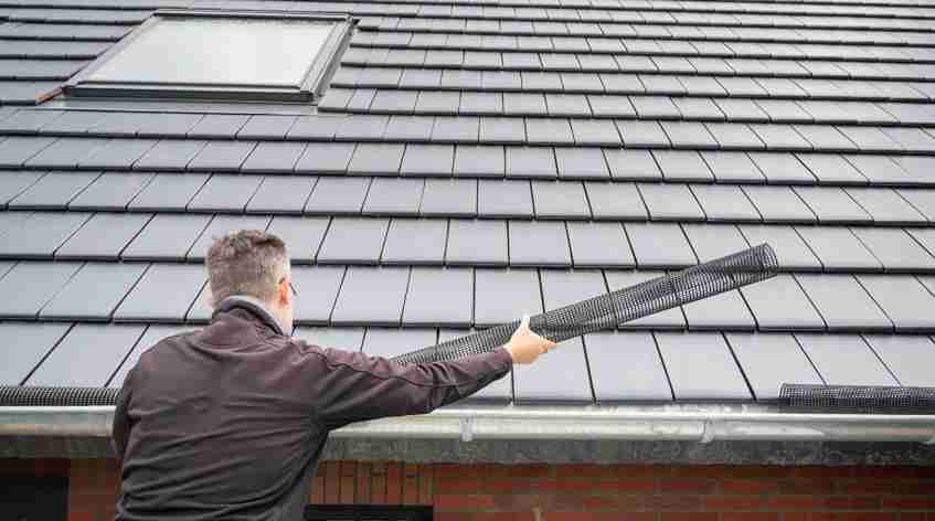 Dallas home remodeling company technician performing gutter maintenance preventing ice dam formation North Texas winter